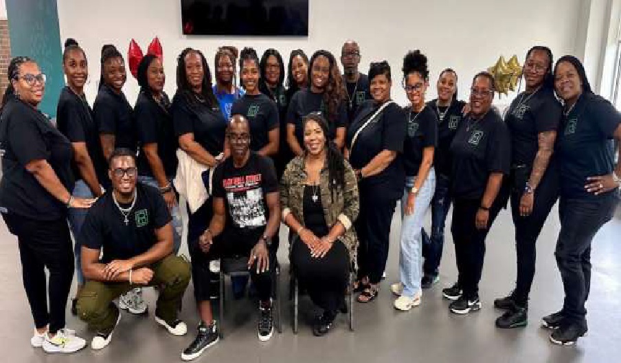 Group photo of diverse people in casual attire smiling indoors.